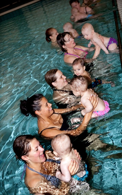 Kvinnor som är i bassäng med barn på babysim